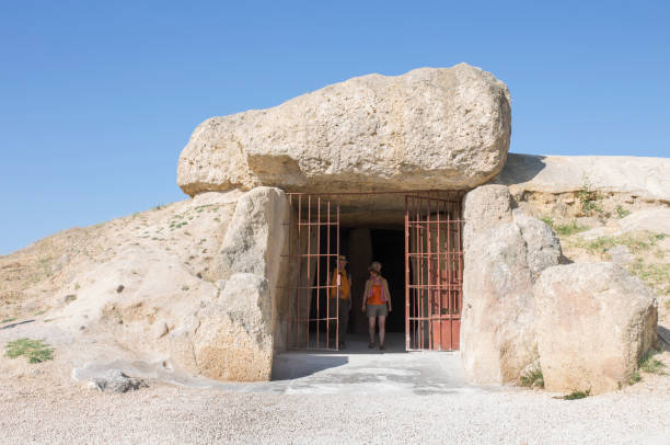 visitors at entrance to dolmen of menga in antequera, spain - dolmen imagens e fotografias de stock