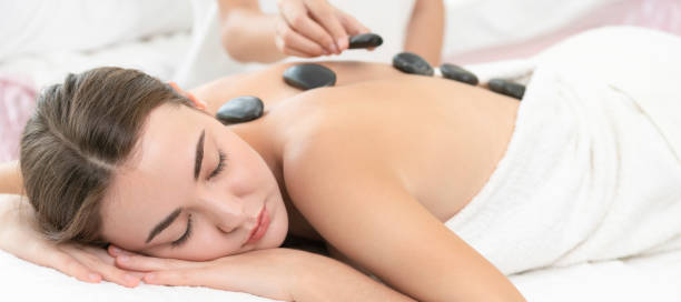 ホットス トーン マッサージ、スパのセラピストによるトリートメントです。 - massaging spa treatment stone massage therapist ストックフォトと画像