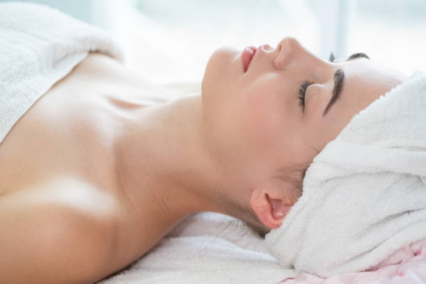 istock Relaxed young woman lying on spa bed for massage. 999852230