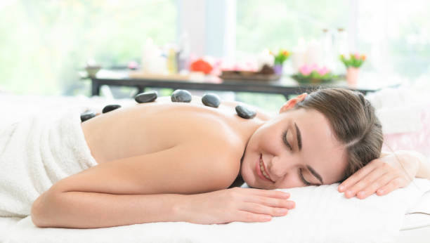 istock Hot stone massage treatment by therapist in spa. 999852240