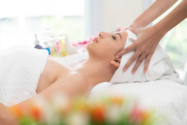 istock Relaxed young woman lying on spa bed for massage. 999852304
