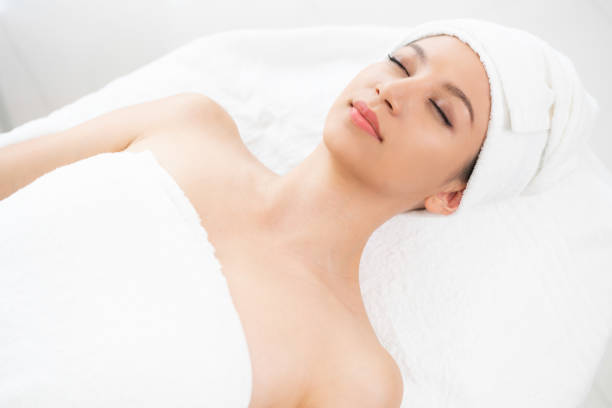 istock Relaxed young woman lying on spa bed for massage. 999852320
