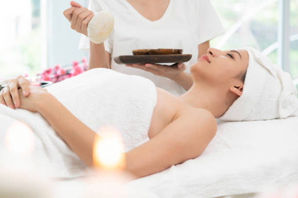 istock Massage therapist using herbal compress with woman 999852360