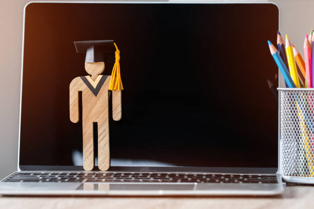 E-learning online Back to School concept People Sign wood with Black Graduation celebrating cap on computer screen near pencil box. Alternative studying anywhere anytime distance graduate education e-learning en línea parte posteriora a escuela concepto signo gente de madera con graduación negro celebrando la tapa en la pantalla del ordenador junto a la caja de lápices. posgrado a distancia alternativa estudiar en cualquier lugar en cualquier mome