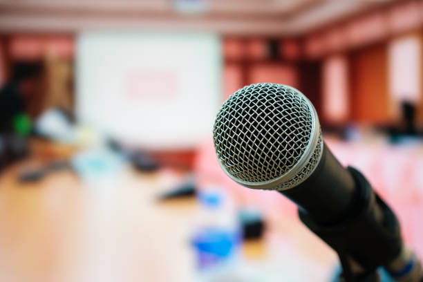 istock Seminar Conference Concept : Microphones for speech or speaking  in seminar room, talking for lecture to audience university, Event light convention hall Background. 999865730