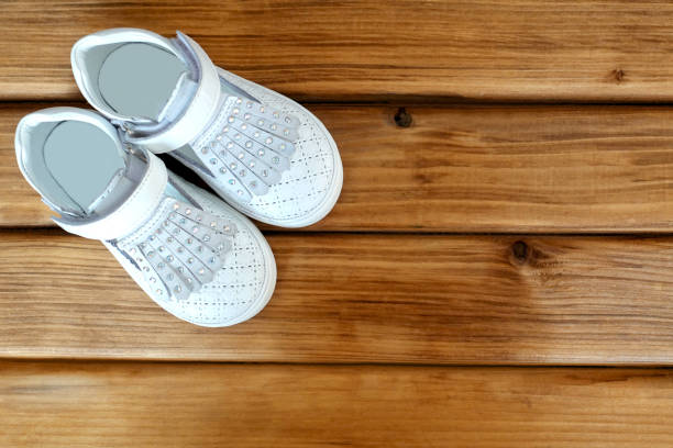 istock Children's white shoes on a wooden 999865880