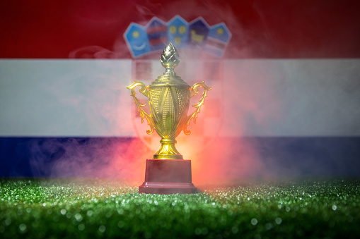 Croatia flag, golden championâs cup on grass.Concept sport. Selective focus