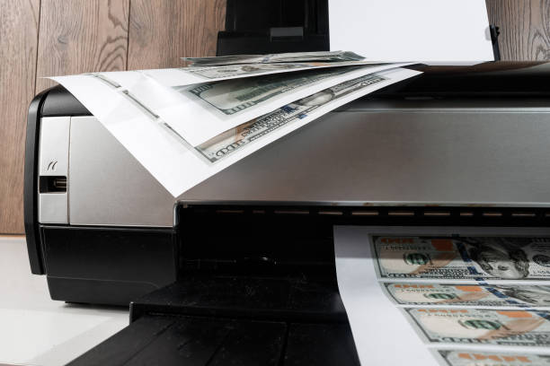 istock Printer and printed US dollars, counterfeit banknotes, currency counterfeiting. Counterfeiters, printing press, inflation. 999869208