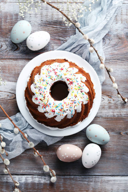 istock Bundt cake with sprinkles and easter eggs on wooden table 999872384