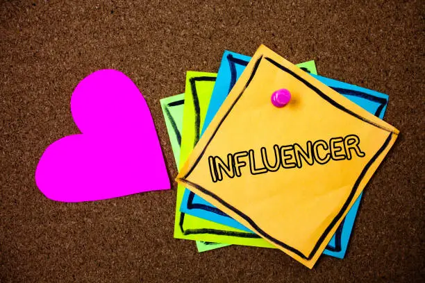 Photo of Word writing text Influencer. Business concept for Person who influences and affect decisions opinions of others Ideas messages paper pink heart cork background love lovely thoughts.