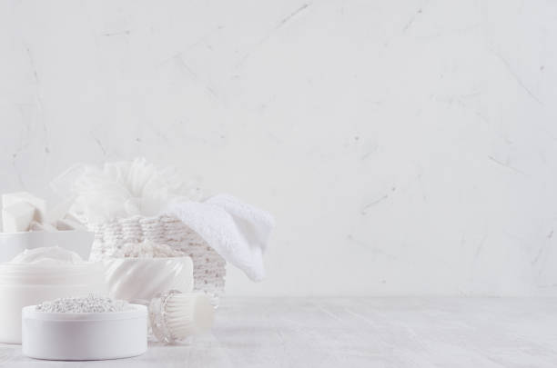 istock White spa cosmetics products and light bath accessories on white wood background, interior, copy space. 999879844