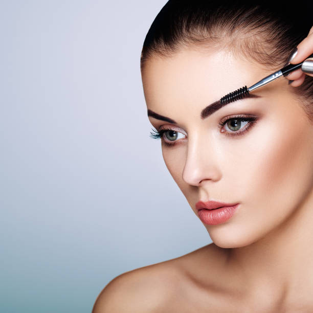 istock Beautiful brunette woman paints the eyebrows 999890168