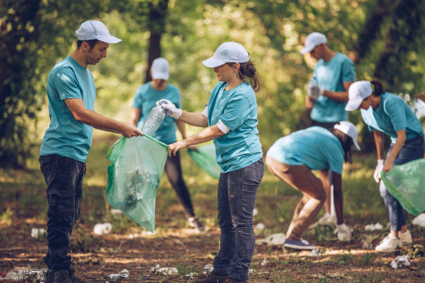 istock Group of volunteers picking up trash in park 999890354