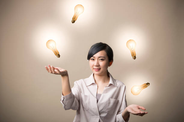 istock Young woman juggling a light bulb 999892660