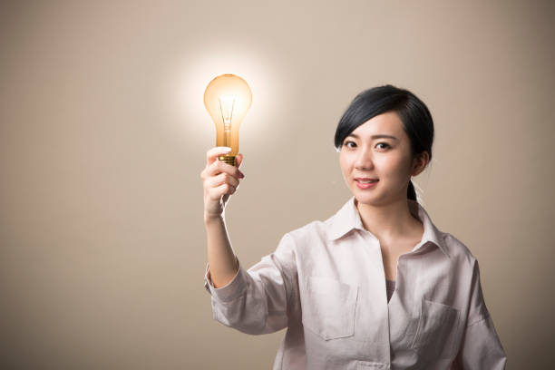 istock Young woman holding a light bulb 999892718