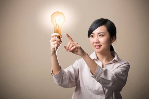 istock Young woman holding a light bulb 999892732