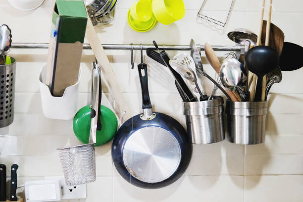 istock Kitchen utensils hanging on white wall in modern kitchen.Hanging copper kitchenware set. 999892752