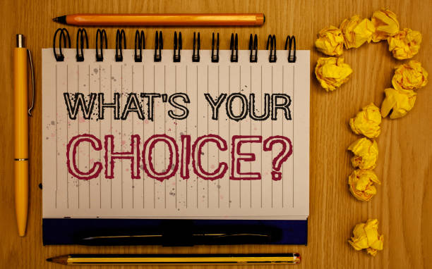 istock Text sign showing What S Your Choice Question. Conceptual photo Option Decision Preferred Opinion Preference Notepad with outline text pen pencil woody desk crimp balls form query mark. 999896066