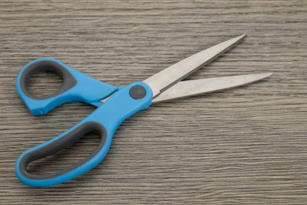 istock Metal blue scissors on a decorated wood table composition 999899496