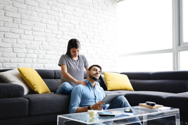 istock Girl Massaging Boyfriend On Sofa At Home 999926902