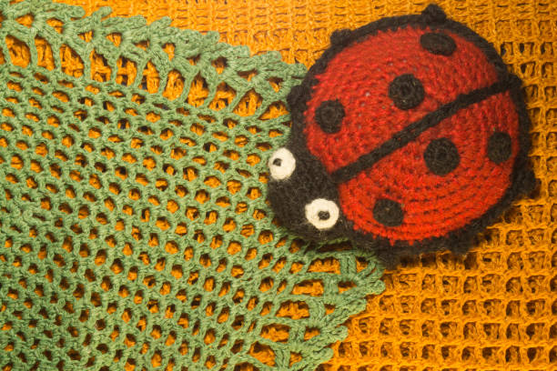 istock Knitting wool toy ladybug on the blamket colorful texture background 999935050