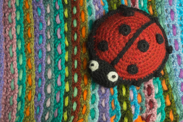 Handmade knitted ladybug toy colorful background