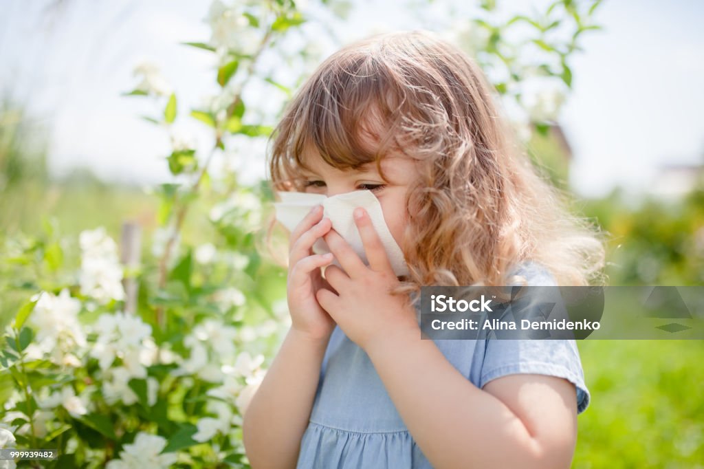 Allergie-Konzept. Kleines Mädchen bläst ihre Nase in der Nähe von blühenden Baum. - Lizenzfrei Kind Stock-Foto