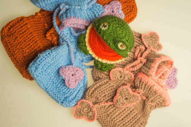 istock Wool knitted toy frog with baby booties background 999939552