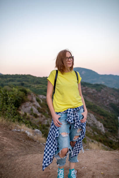 istock Pretty Young Woman looking off a cliff into valley 999950802