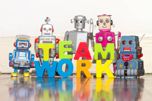 istock the word TEAM WORK  with wooden letters and 5 retro bots 999978528