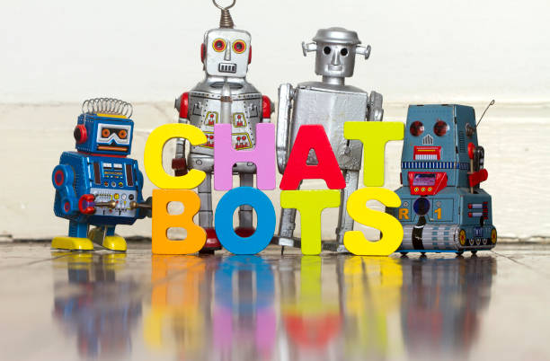 istock the word  CHAT BOTS with 4 retro robots on a wooden floor 999978586