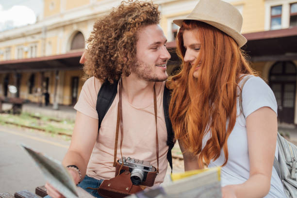 istock Young photographer looking at girl reading a map 999979084
