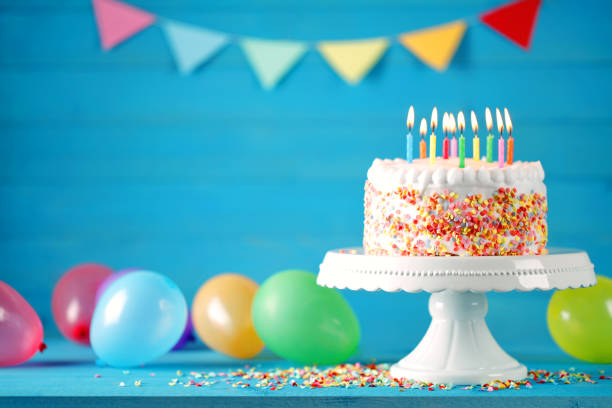 с днем рождения торт с горящими свечами, воздушные шары и вымпел - годовщина фотографии стоковые фото и изображения