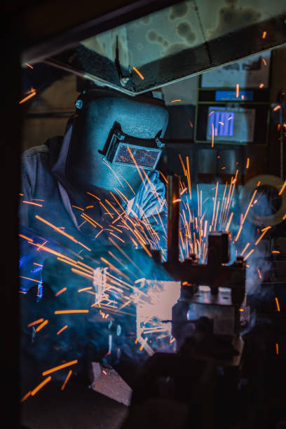istock Industrial worker is welding in factory 999988172