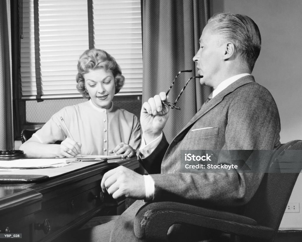 Man talking, woman taking notes  Office Stock Photo