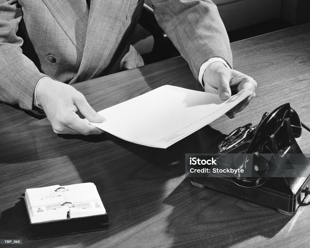 Hombre toma mano de retención de documentos - Foto de stock de 1950-1959 libre de derechos