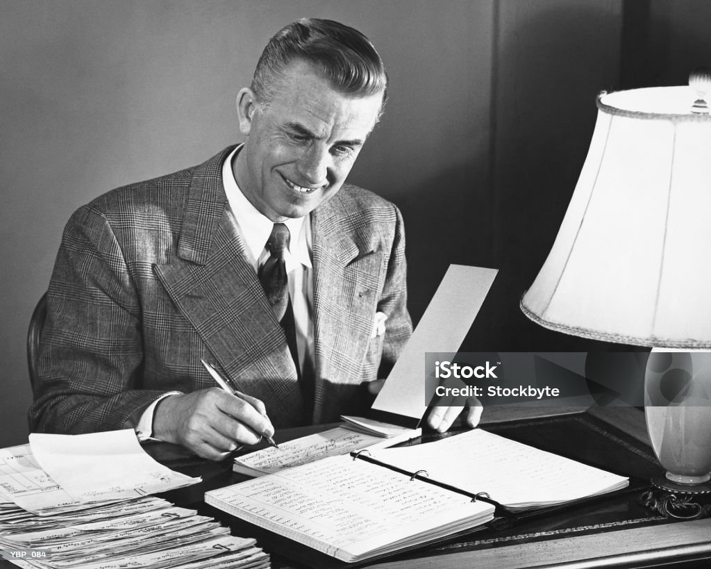 Man signing checks  The Past Stock Photo