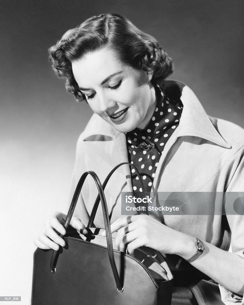 Mujer mirando a bolso - Foto de stock de 1950-1959 libre de derechos