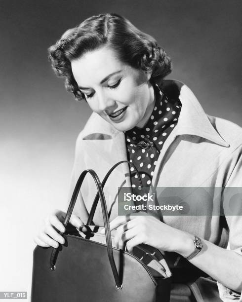 Mujer Mirando A Bolso Foto de stock y más banco de imágenes de 1950-1959 - 1950-1959, Venta al por menor, Ir de compras