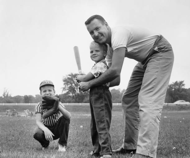 vater und zwei söhne spielen baseball - baseball hitting baseball player child stock-fotos und bilder