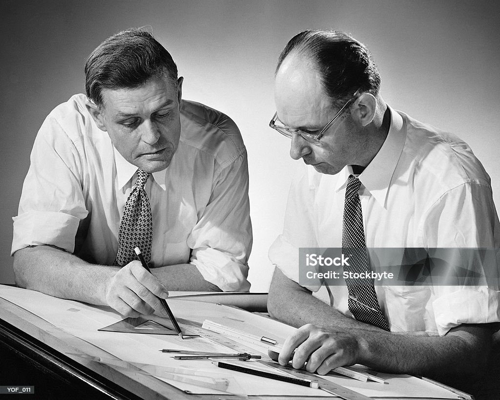 Zwei Männer bei der Ausarbeitung Tisch - Lizenzfrei 1950-1959 Stock-Foto