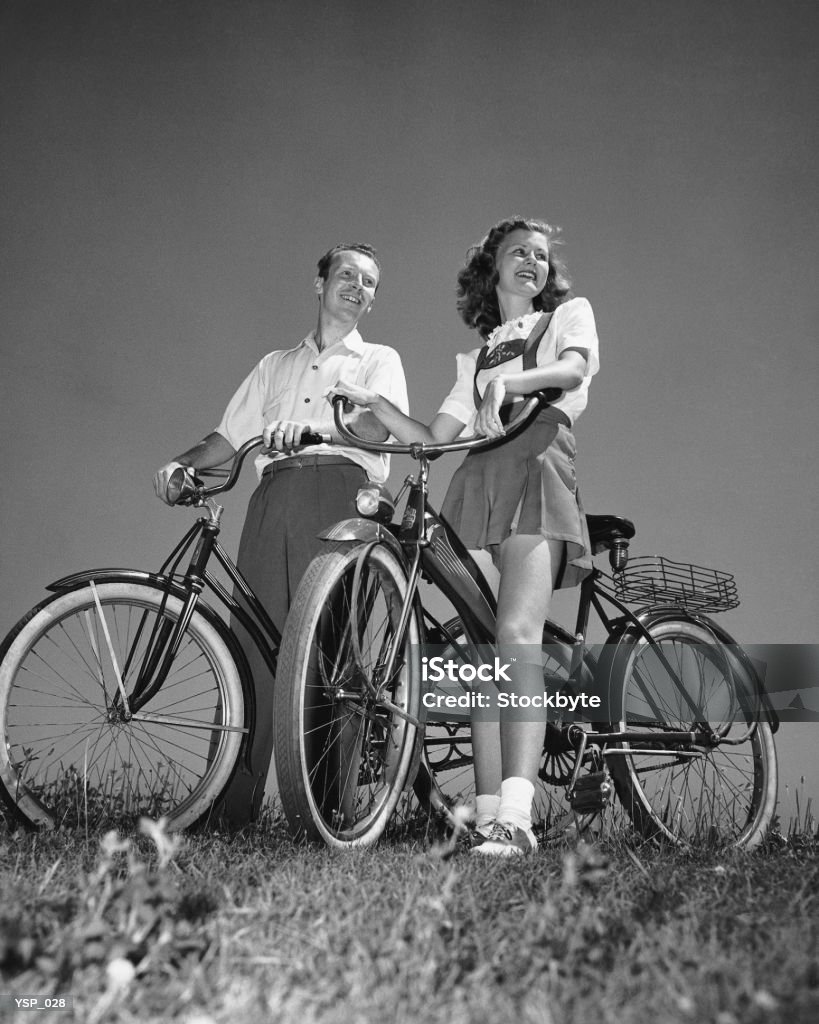 Couple standing with bicycles  1950-1959 Stock Photo