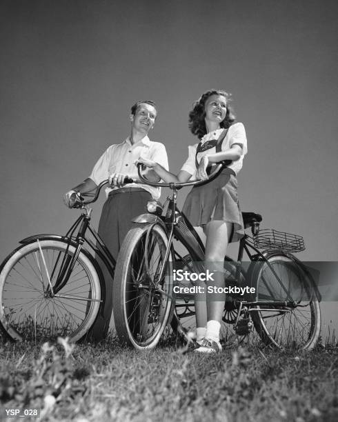Couple Standing With Bicycles Stock Photo - Download Image Now - 1950-1959, Photography, Bicycle