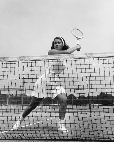Female tennis player with racket ready to serve tennis ball, black and white portrait