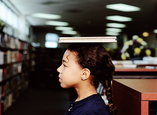 girl balancing a book on her head - balance book student latin american and hispanic ethnicity 뉴스 사진 이미지