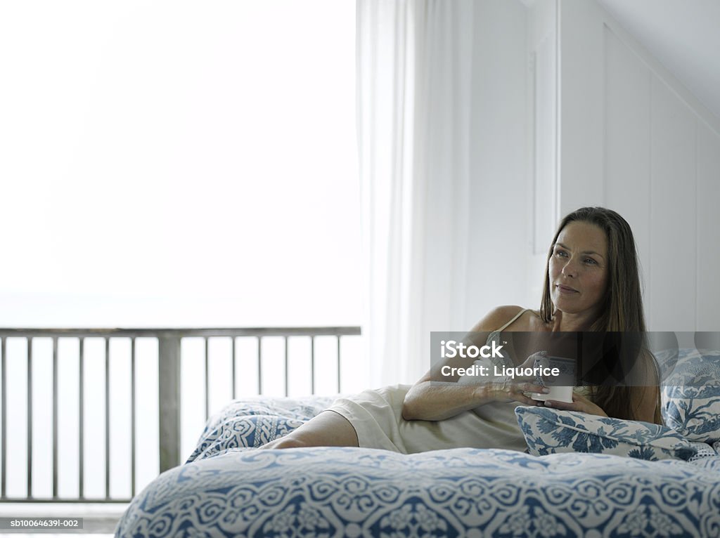 Mulher Madura na cama retenção e caneca de café - Royalty-free 45-49 anos Foto de stock