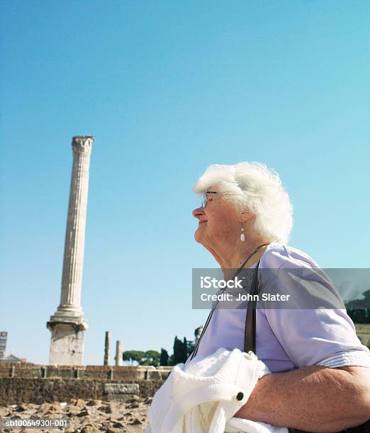 Senior Woman At Ancient Site Side View Stock Photo - Download Image Now - 70-79 Years, Active Seniors, Adults Only