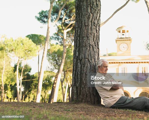 Senior Man Leaning On Tree Trunk Eyes Closed Stock Photo - Download Image Now - 70-79 Years, Active Seniors, Adults Only