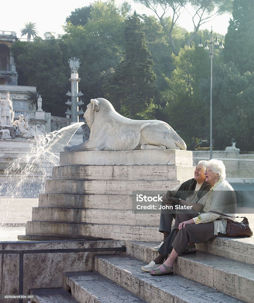 Senior couple sitting on steps, smiling  Sitting Stock Photo