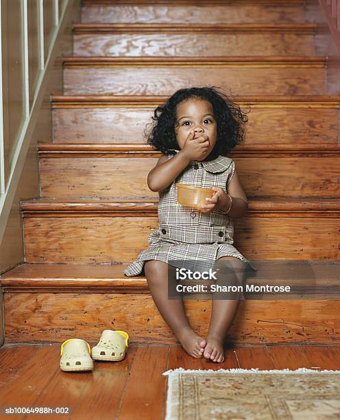 Girl Sitting On Steps Eating Snacks Portrait - Fotografias de stock e mais imagens de Escadaria